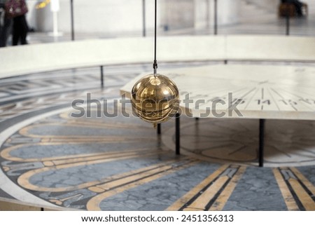 Foucault pendulum hanging from pantheon ceiling in Paris