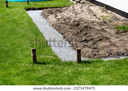Foundation footings poured in a ditch in the yard, building a terrace in the backyard.