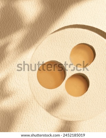 foundation samples on glass with shadows and warm backdrop