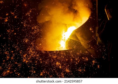 Foundry. Pouring Hot Metal From A Ladle Into Molds. Bright Red Metal And Sparks Flying To The Sides