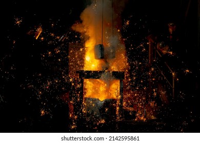 Foundry. Pouring Hot Metal From A Ladle Into Molds. Bright Red Metal And Sparks Flying To The Sides