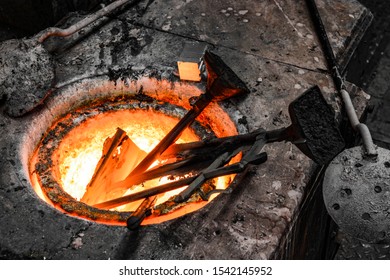 In A Foundry Workshop. Bronze Metal Bars Are Melted In A Crucible