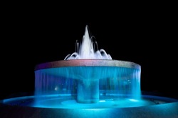 Fountain Bath Decorates The Garden Beautifully At Night.Fountain With Colored Lights In Celebration On Black Background.