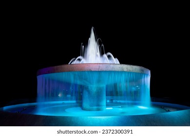 Fountain bath decorates the garden beautifully at night.Fountain with colored lights in celebration on black background.