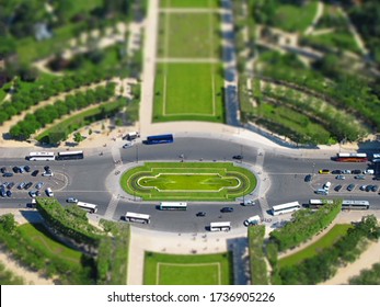 The fountain of Champ de Mars park in Paris, France is shown from an elevated, miniature / tilt-shift style view.