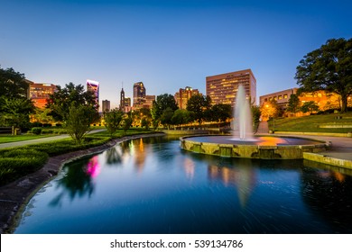 Fountain and lake at Marshall Park and the Uptown skyline at night, in Uptown Charlotte, North Carolina.