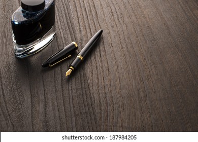 Fountain Pen And Ink Bottle On Table