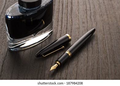 Fountain Pen And Ink Bottle On Table