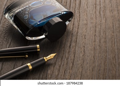 Fountain Pen And Ink Bottle On Table