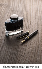 Fountain Pen And Ink Bottle On Table