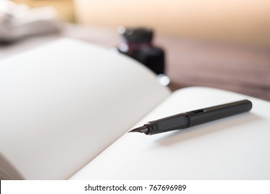 Fountain Pen, Notebook, Ink on wooden table - Shutterstock ID 767696989