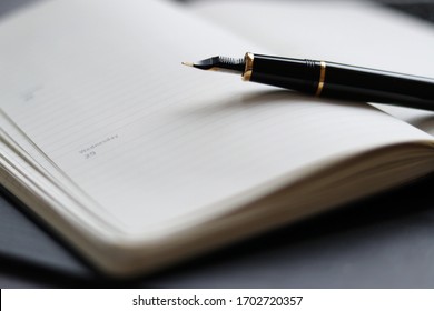 A fountain pen on top of an agenda
