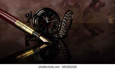 Fountain pen and pocket watch on mirrored surface with blurred background, selective focus. - Powered by Shutterstock