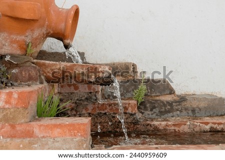 Fountain through which a slight trickle of water runs in Sanlúcar de Guadiana, Spain. Fountain made of traditional clay basins. Located on Cabezo Street.