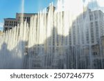 the fountains of the bellagio hotel in las vegas with the sun reflecting on the water