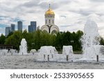 Fountains and the Church of St. George on Poklonnaya Hill overlooking the Moscow City business complex. Moscow