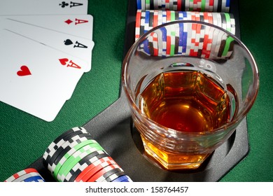 Four aces, glass of whiskey and chips on a poker table - Powered by Shutterstock