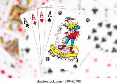 four aces and a joker on the background of scattered cards - Shutterstock ID 599498798