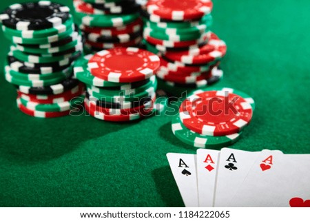 Four aces and a stack of poker chips. 