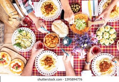 Four Adult People At Sunday Brunch With The Family. All Together Outdoor Toasting With A Rose Wine. Rustic Corner With Wooden Table And Checkered Tablecloth. Vegetables Food And Salad.