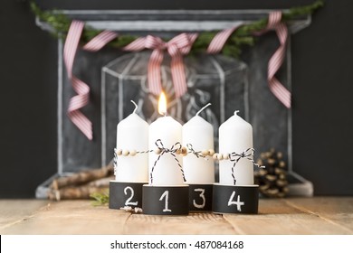 four advent christmas candles in black and white