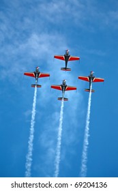 four airplanes in formation on airshow