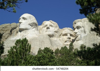 Four American Presidents framed by bushes and ponderosa pine trees at Mount Rushmore National Memorial, South Dakota