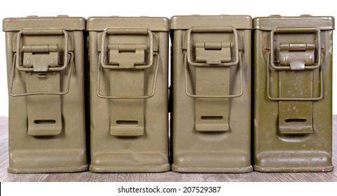 four ammunition boxes on wooden table