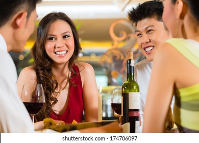 Four Asian Chinese Business People Having Dinner In Elegant Club Restaurant Or Hotel