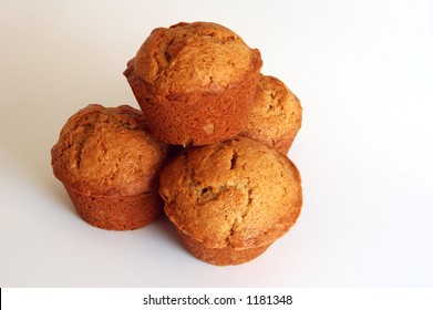 Four Banana Bread Muffins On A White Background.