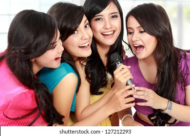 Four Beautiful Stylish Woman Singing Karaoke Together