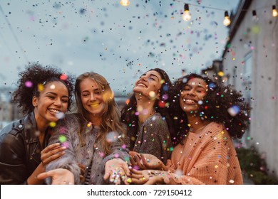 Four Beautiful Women Standing At A Terrace Under Confetti.