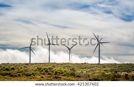 Four big wind generators in the mountain field over the clouds. Madeira island, ER105 road, Portugal.