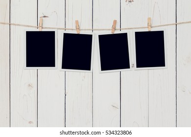 Four blank photo frame hanging on white wood background with space