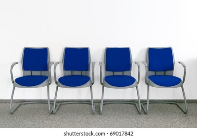 Four Blue Chairs In Simple Empty Waiting Room