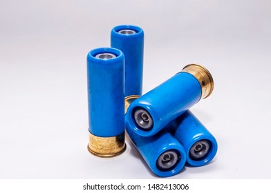 Four blue, rifled 12 gauge shotgun shells on a white background - Shutterstock ID 1482413006