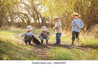 Four boys with fishing rods go on a fishing trip on the narrow rural road in sunny summer day - Shutterstock ID 204641857