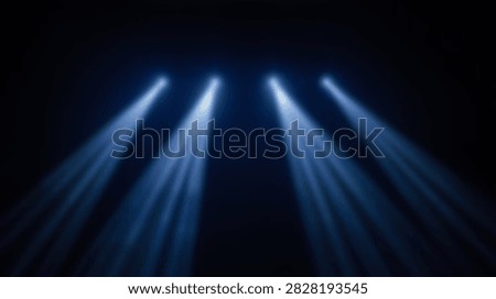 Four bright blue spotlights create visible beams of light against a dark background, suggesting a stage or performance setting.