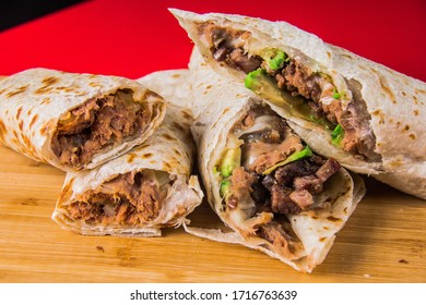 Four Burritos In Red Background