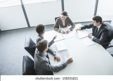 Four Business People Sitting Around A Table And Having A Business Meeting