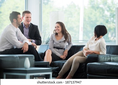 Four Business People Talking On A Break In Modern Environment