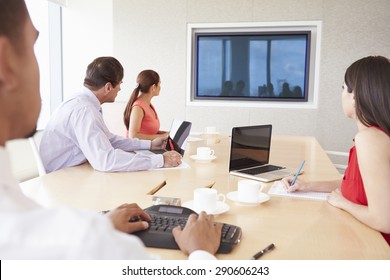 Four Businesspeople Having Video Conference In Boardroom