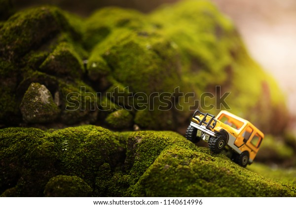 Four by four off road car crossing through  the\
mountain covered with green moss. Travel and racing concept for\
four wheel drive off road vehicle\
.
