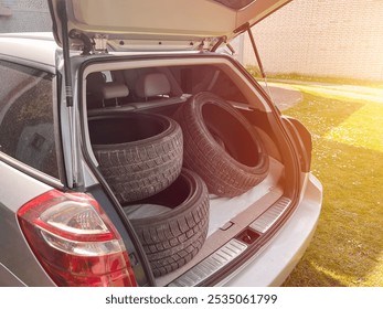 Four car tires stacked in SUV trunk - Powered by Shutterstock