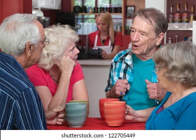 Four Caucasian senior adults with coffee mugs in conversation - Powered by Shutterstock