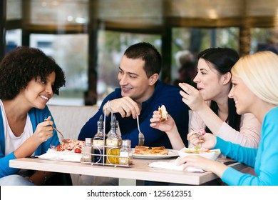 Four Cheerful Friends Chatting While Lunch In Restaurant