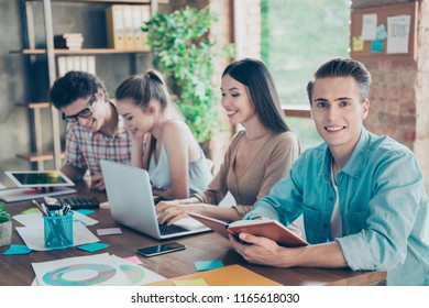 Four cheerful smart, clever people, friends, at meeting, gathering, chatting, discussing, analyzing data, completing test, exam tasks, collaboration light interior room - Powered by Shutterstock