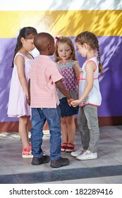 Four children dancing in circle in a kindergarten class