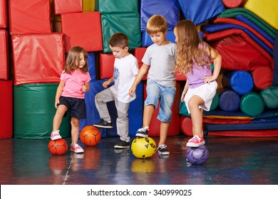 Four Children Playing Soccer In Gym Of Kindergarten Together