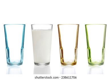 Four colorful drinking glasses, one with milk - Shutterstock ID 238611706